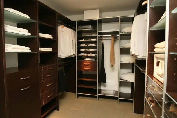 Creative vertical design and layout in a small walk-in closet using custom closet systems