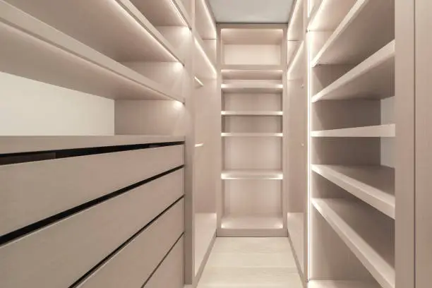 Modern custom closet systems designed to maximize small walk in closet spaces with smart shelving and lighting