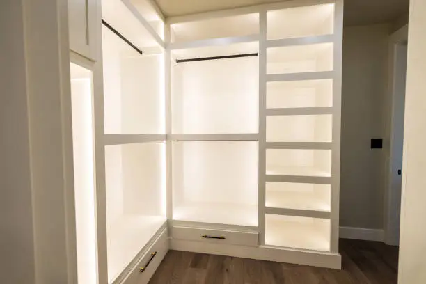 A finished custom walk-in closet installed by KBR Closet with labeled zones and soft lighting