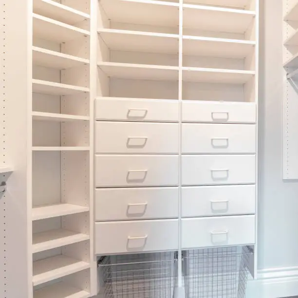 Custom closet systems for walk-in closets with organized drawers, open shelving, and accessory trays