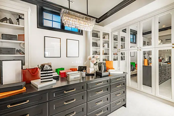 Luxury closet systems for walk-in closets with island drawers and floor-to-ceiling cabinetry