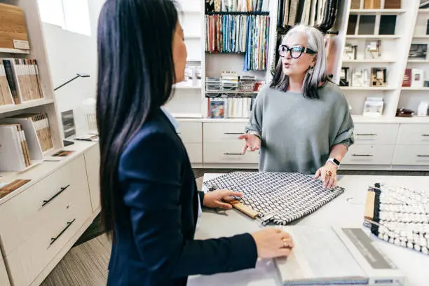 A consultation in a showroom with a designer discussing pet-friendly closet designs using 3D renderings.