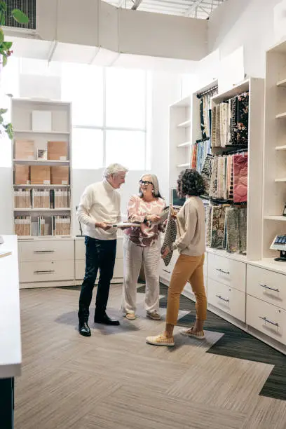 A family consulting with a designer in a showroom, reviewing 3D renderings for a shared kids’ closet design.