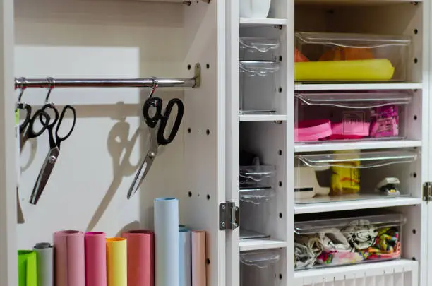 A close-up of a hobby closet with adjustable shelves, built-in drawers, and pegboards for art or sports equipment.