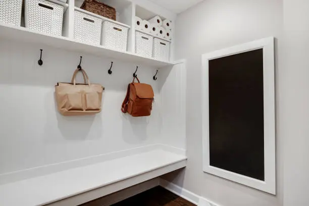 A mudroom closet with a built-in pet station, including hooks, bins, and a drying rack for pet gear.
