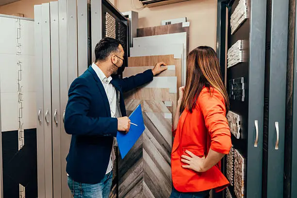 A consultation with a designer in a showroom, discussing guest room closet designs with 3D renderings.