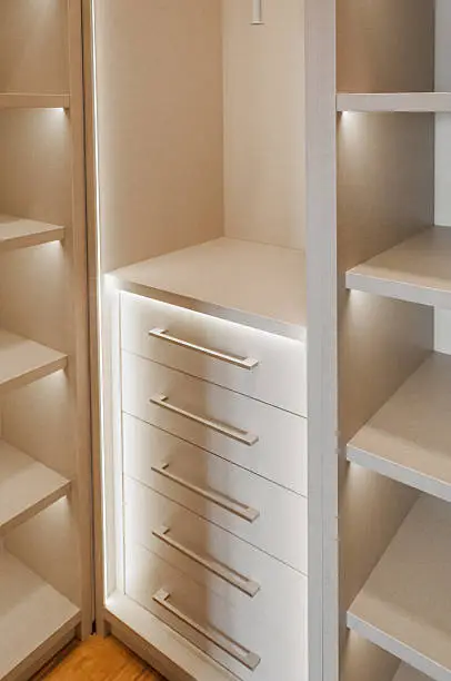 A close-up of a closet with adjustable shelves, LED lighting, and lockable drawers, designed for business efficiency.