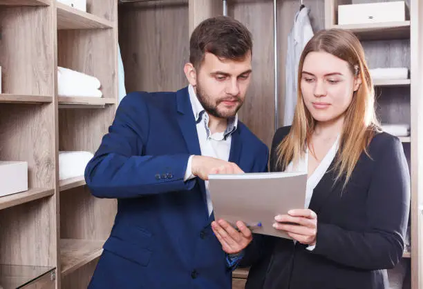 A close-up of a client reviewing a 3D rendering of a custom closet design with a closet company representative