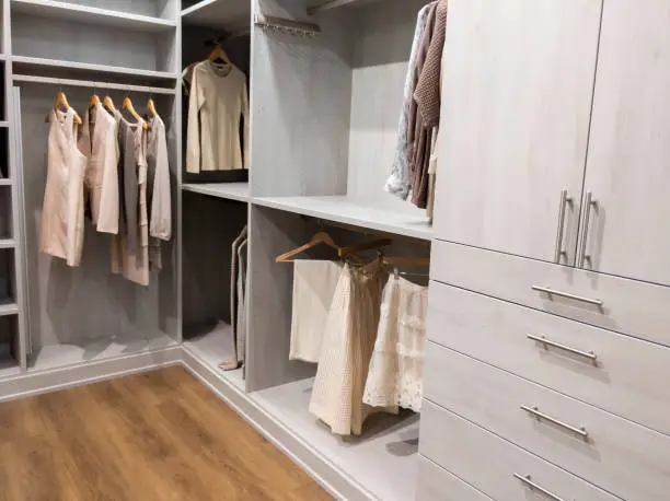 A serene custom closet with clean lines, neutral tones, and labeled storage, promoting a calming closet space