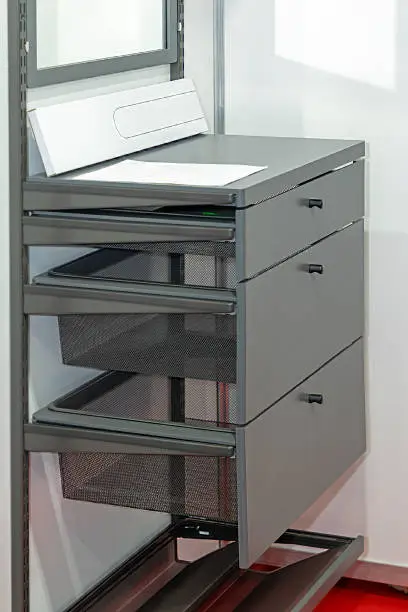 A close-up of a closet with adjustable shelves, cable management, and built-in drawers for office supplies