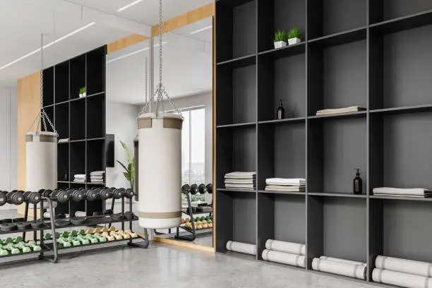 A modern home gym with a custom closet system featuring shelves, cubbies, and ventilated cabinets for fitness gear