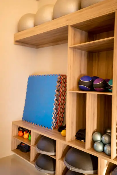 A walk-in closet converted into a fitness room with foldable workout surfaces and organized storage for gear