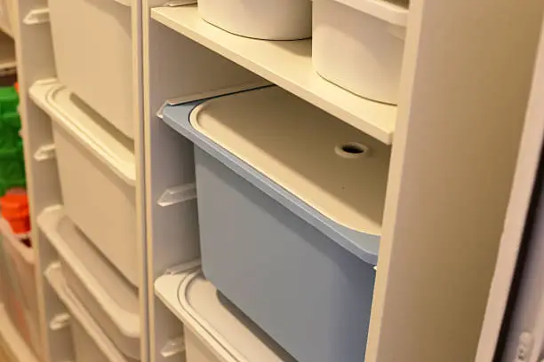 A close-up of a pet closet with built-in drawers, hooks, and pull-out bins for food and grooming supplies