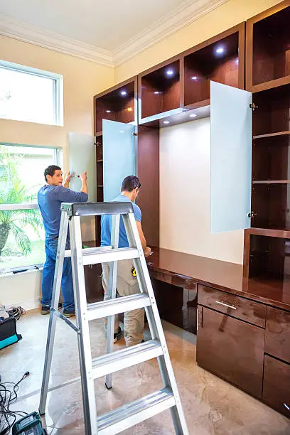 A professional installation team setting up a custom closet in a modern home, showcasing expertise