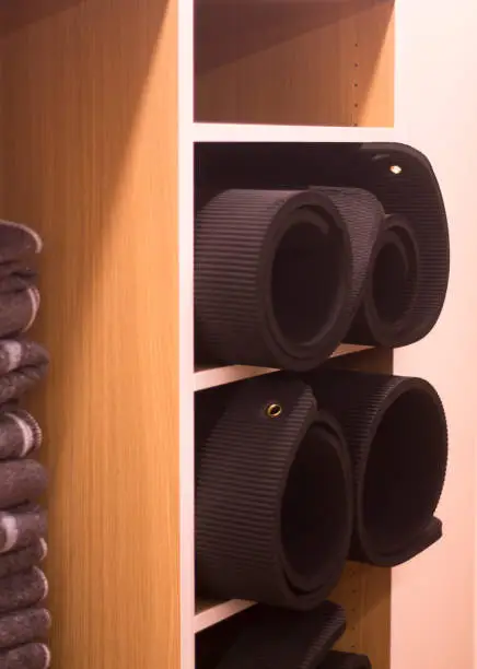 A close-up of a closet with shelves, drawers, and ventilated cabinets for yoga mats, dumbbells, and shoes