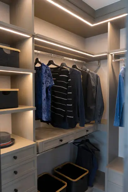 A tidy custom closet with soft-close drawers, LED lighting, and neutral finishes for peace
