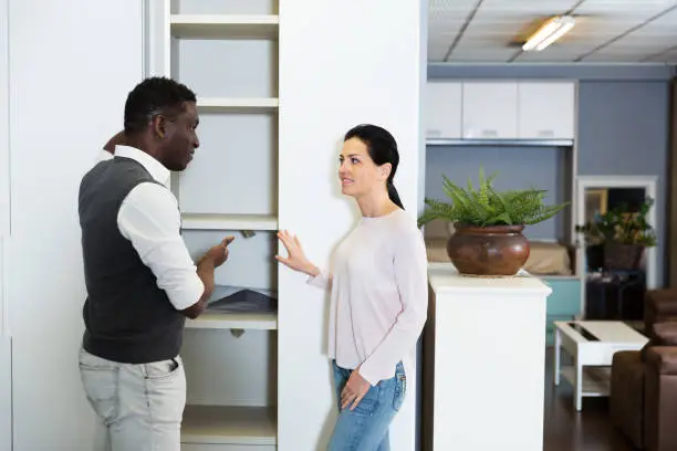 A consultation in a showroom with a designer discussing reach-in closet designs using 3D renderings
