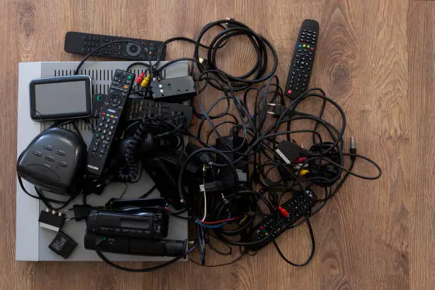 A cluttered entertainment area with tangled wires and scattered devices, highlighting the need for a custom media center