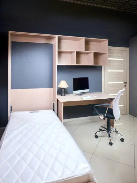 A Murphy Bed in a small apartment, folded up to reveal shelves and a workspace, perfect for urban living