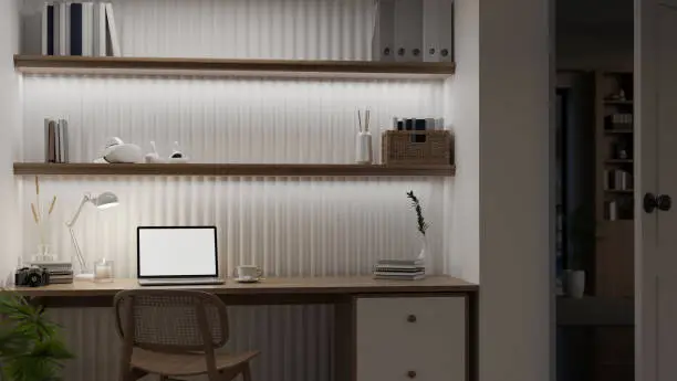 A close-up of a home office closet with a compact desk, LED lighting, and adjustable shelves for devices