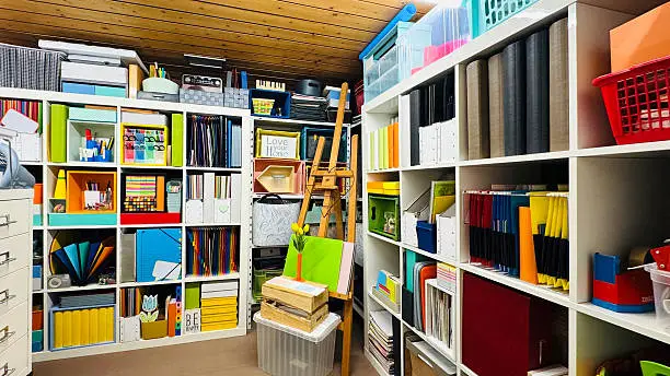A creative home office closet with colorful bins and shelves for art supplies, designed for an artist’s workflow
