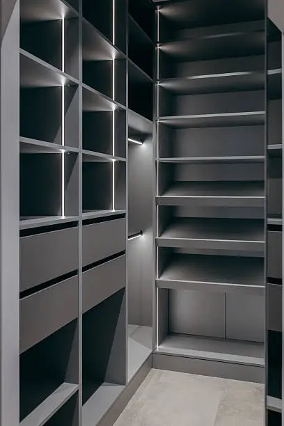 A close-up of a closet with velvet-lined drawers, adjustable shelves, and integrated lighting for luxury