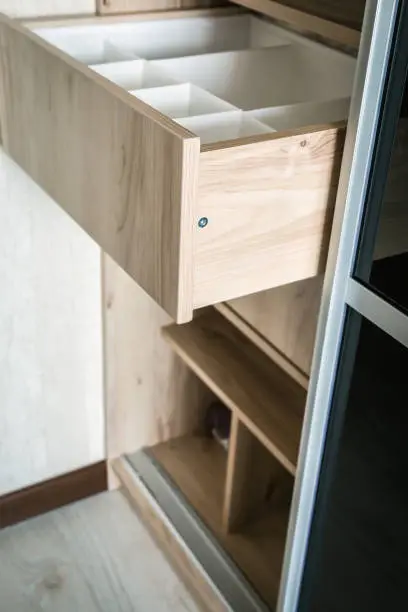 A close-up of a small closet with sliding doors, vertical shelving, and pull-out organizers, designed for efficiency
